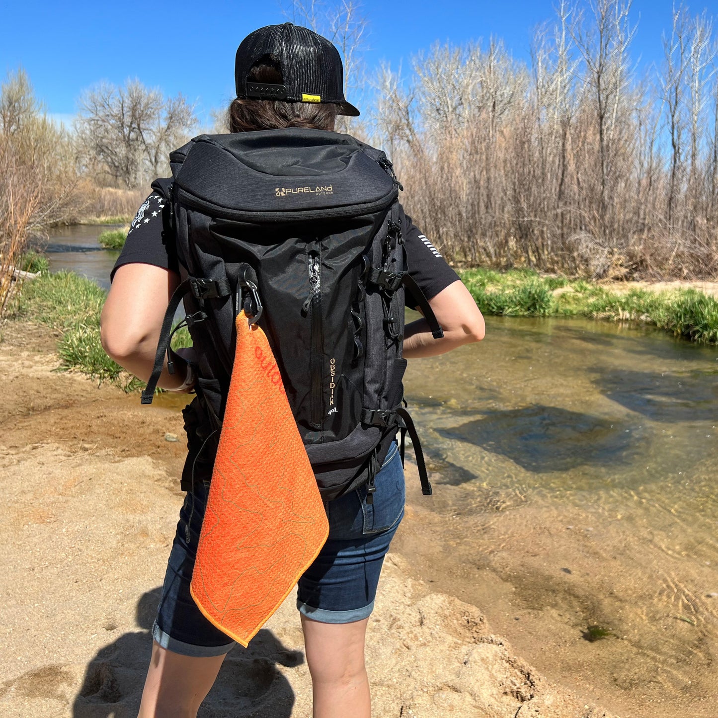 Camp kitchen towel hanging from camping backpack